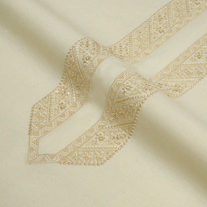 Close-up of beige fabric with intricate gold embroidery